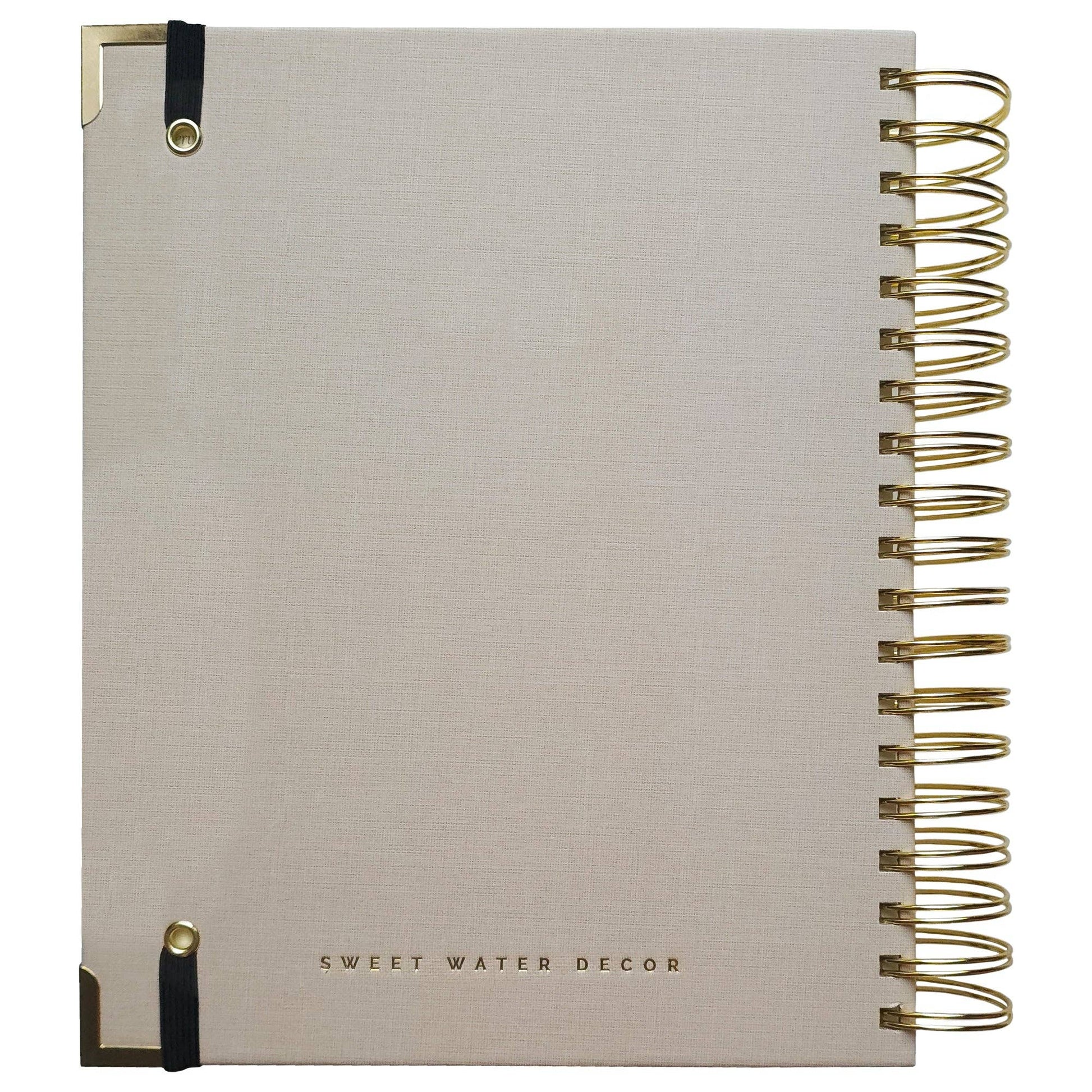 Beige notebook with gold spiral binding and Sweet Water Decor branding on a white background