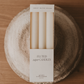 Box of fluted taper candles on a textured surface