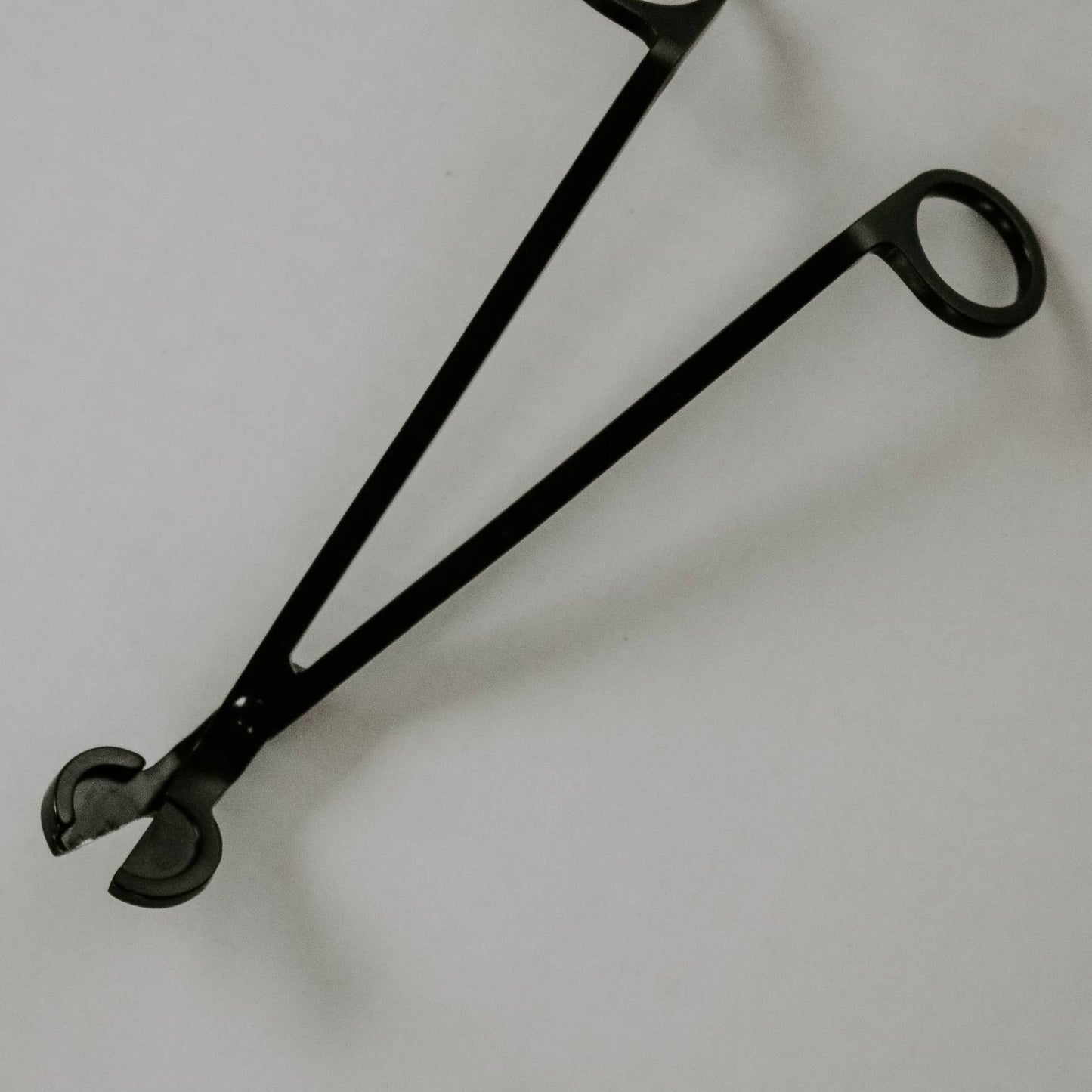 Black metal tool on a light gray background