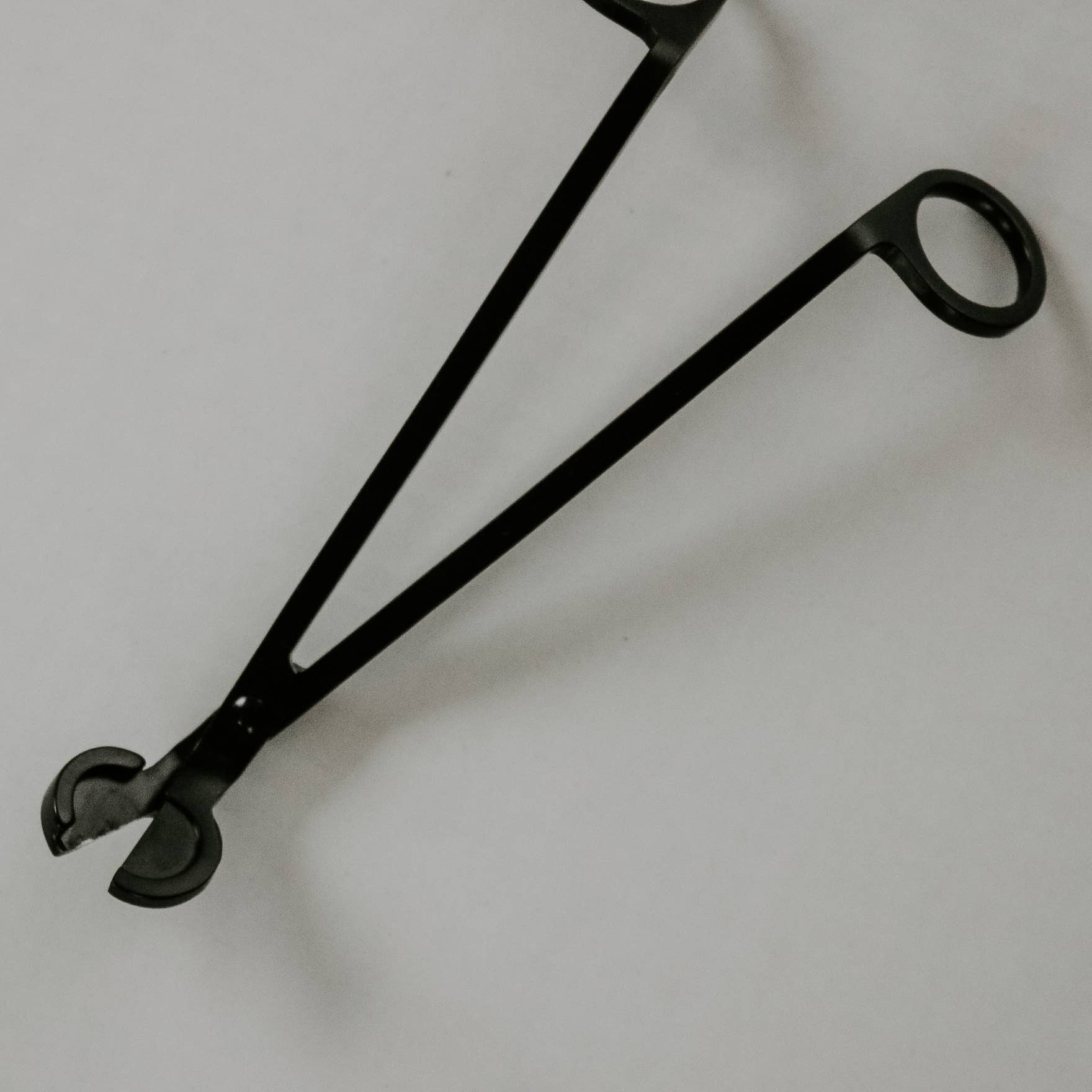 Black metal tool on a light gray background