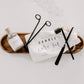 Matte black candle care kit with wick trimmer, candle snuffer, wick dipper, and drawstring storage pouch.