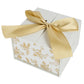 White gift box with gold floral patterns and a gold ribbon on a white background