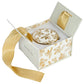 Decorative plate with gold floral design in a matching box with a gold ribbon on a white background